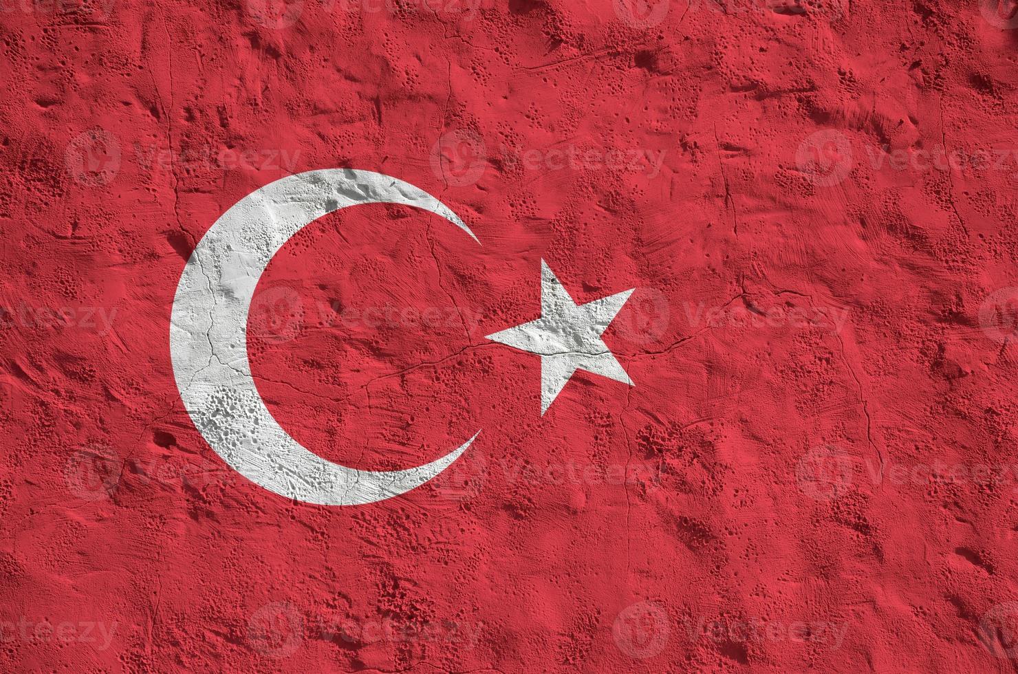 Turkey flag depicted in bright paint colors on old relief plastering wall. Textured banner on rough background photo