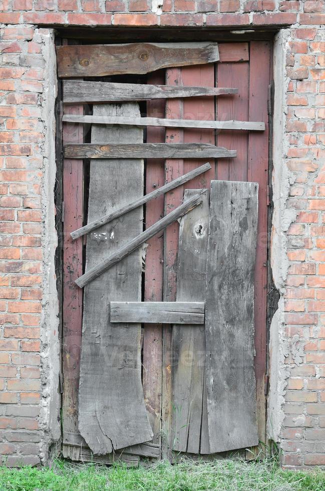 Boarded up wooden door to an old abandoned house photo