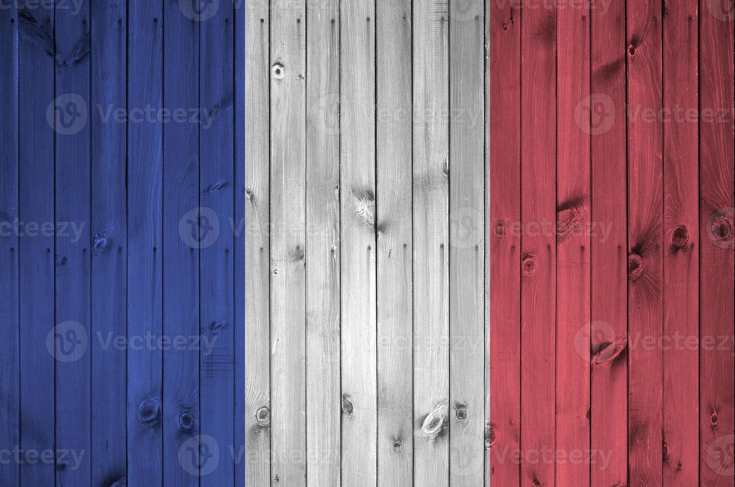 France flag depicted in bright paint colors on old wooden wall. Textured banner on rough background photo