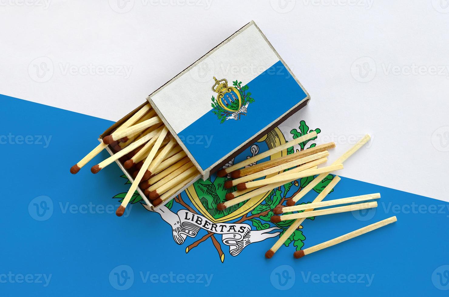San Marino flag  is shown on an open matchbox, from which several matches fall and lies on a large flag photo