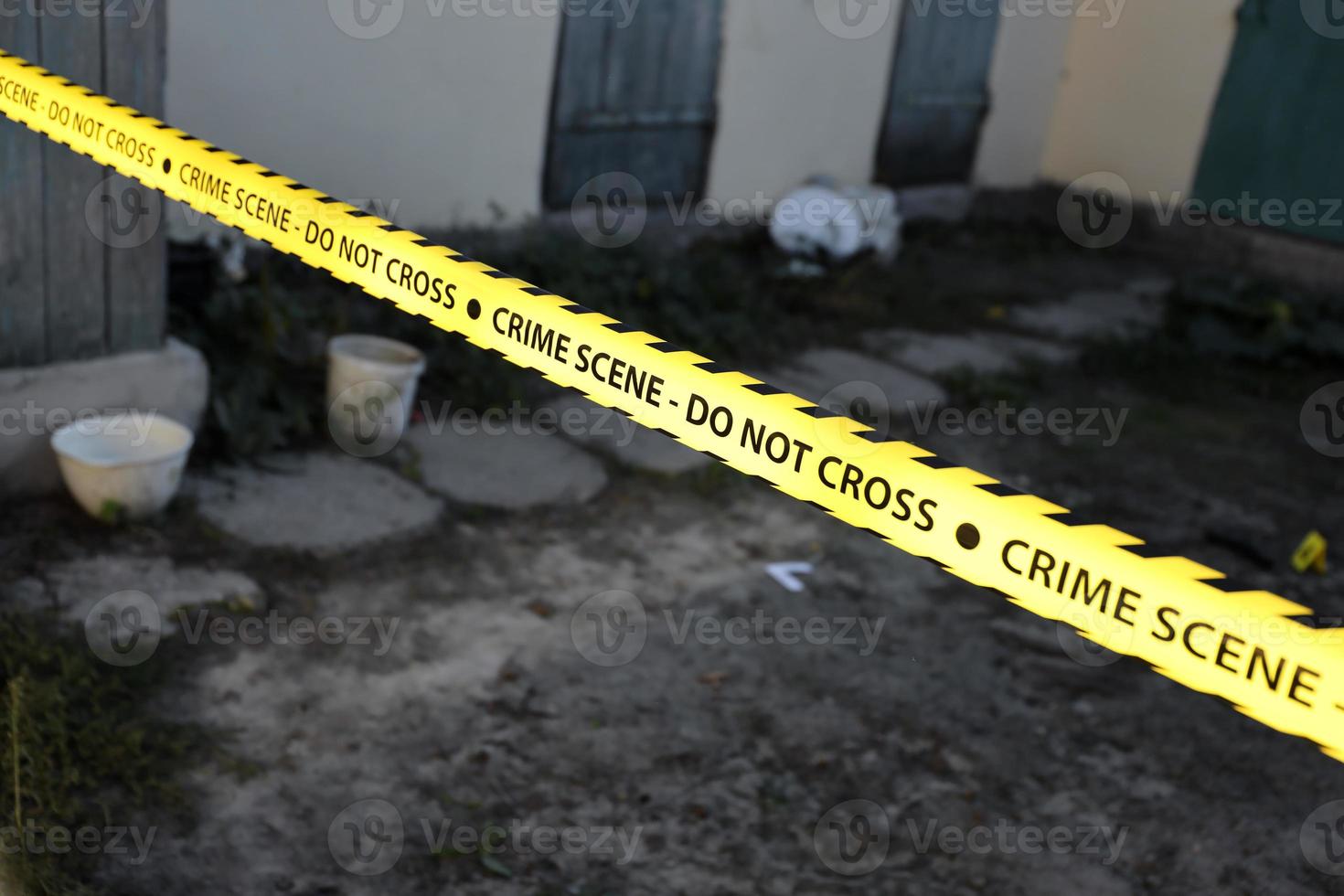 Crime scene tape for covering the area cordon. Yellow tape with blurred forensic law enforcement background in cinematic tone photo