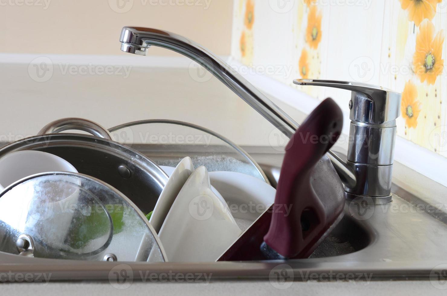 Dirty dishes and unwashed kitchen appliances filled the kitchen sink photo