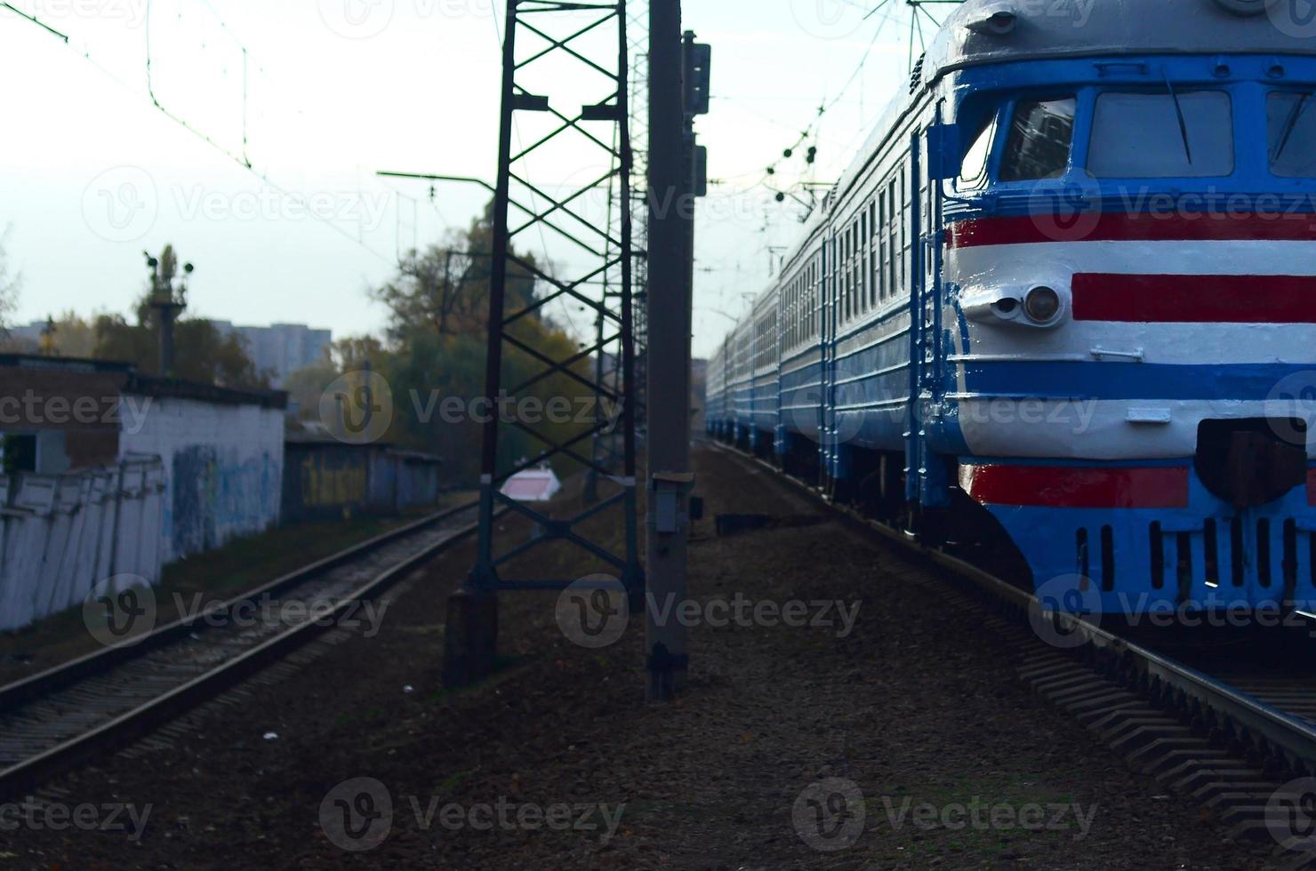 Old soviet electric train with outdated design moving by rail photo