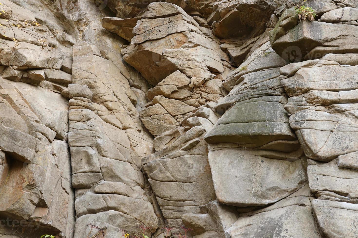 Light coarse natural rock stone background. Mining cliff rough front surface. Big limestone stack backdrop. Heavy grunge damaged granite block texture photo