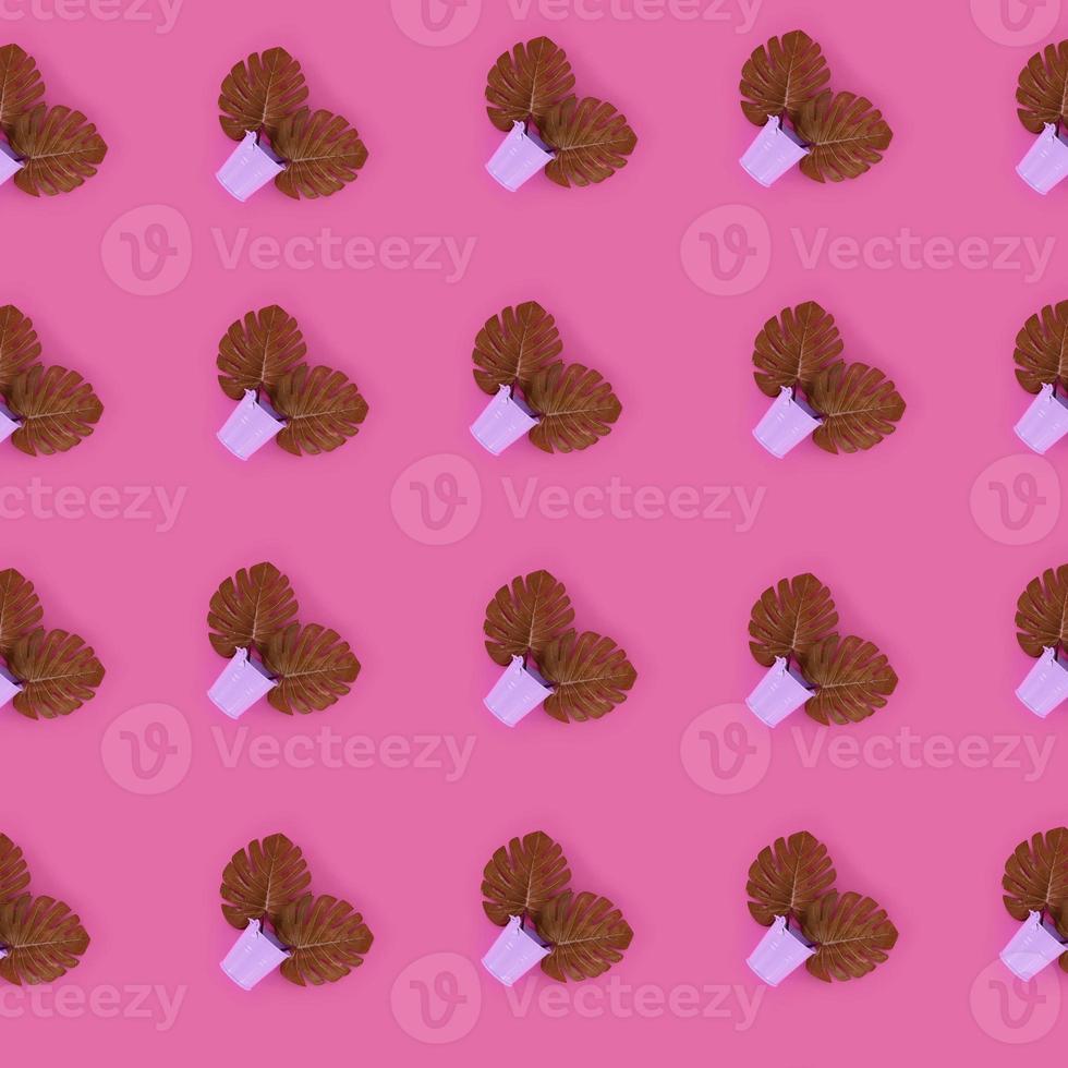Tropical palm monstera leaves lies in a pastel pails on a colored background. Flat lay trendy minimal pattern. Top view photo