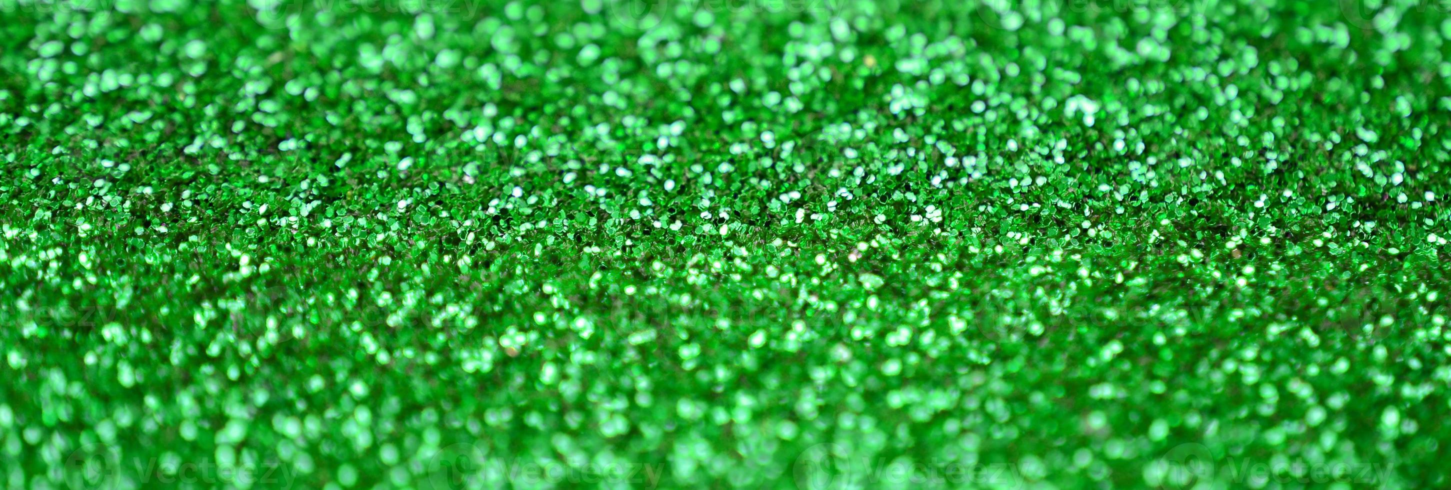 A huge amount of green decorative sequins. Background image with shiny bokeh lights from small elements photo