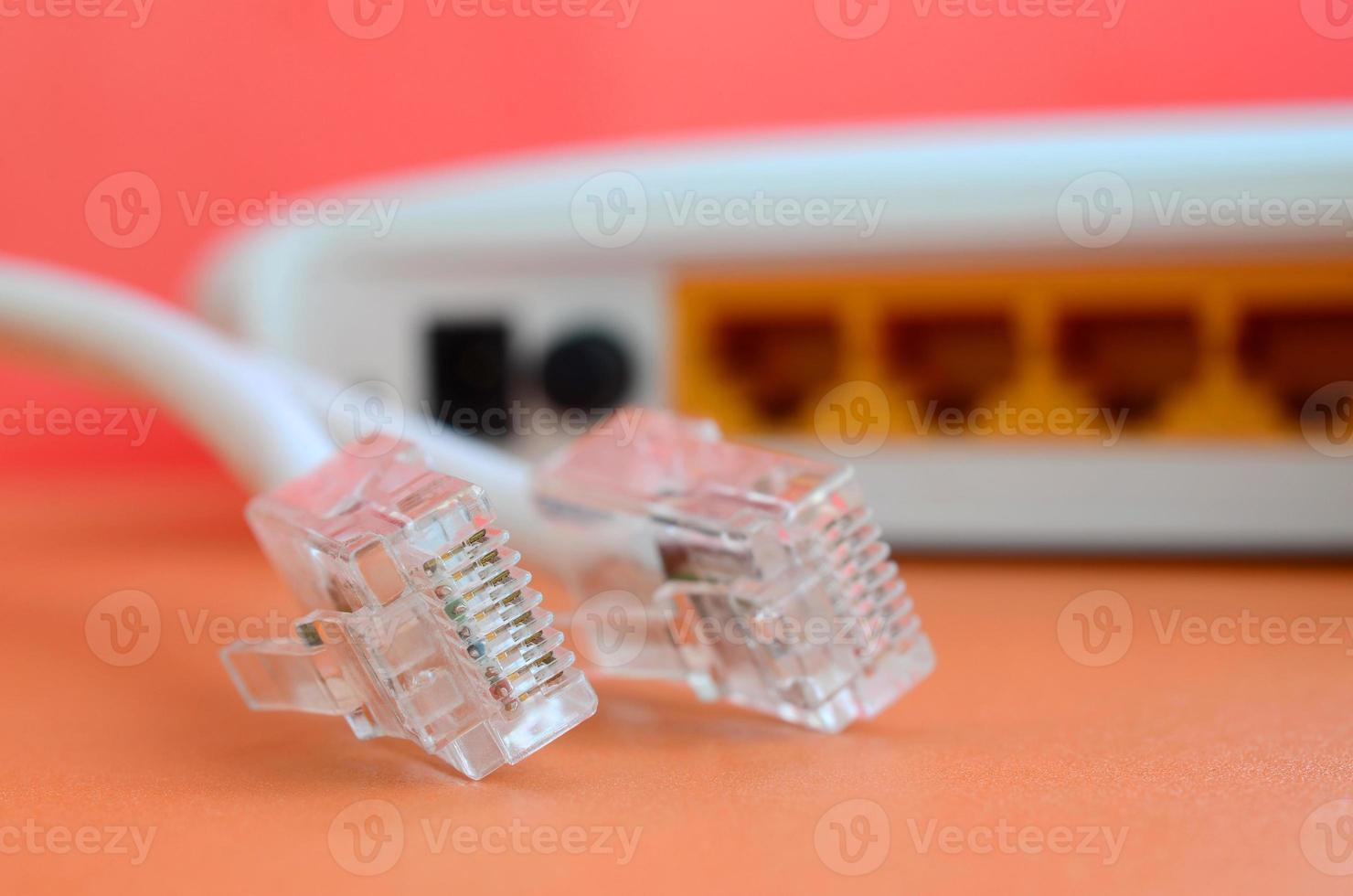 Internet router and Internet cable plugs lie on a bright orange background. Items required for Internet connection photo