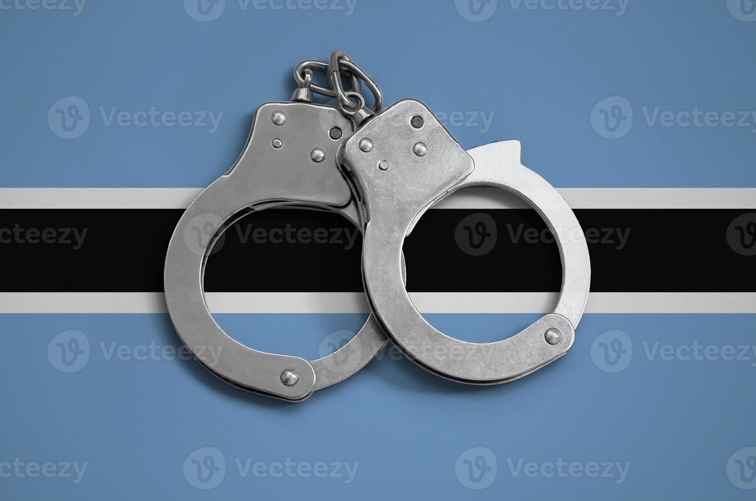 Botswana flag  and police handcuffs. The concept of observance of the law in the country and protection from crime photo