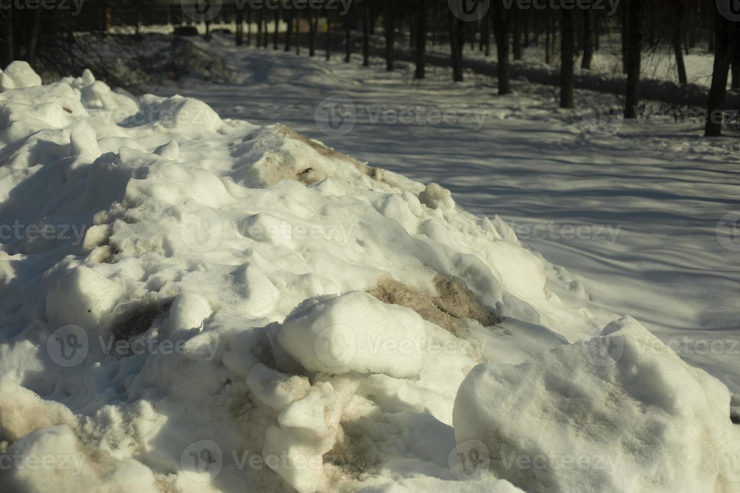 Snow removed from road. Pile of snow outside. Dirty roadside. photo