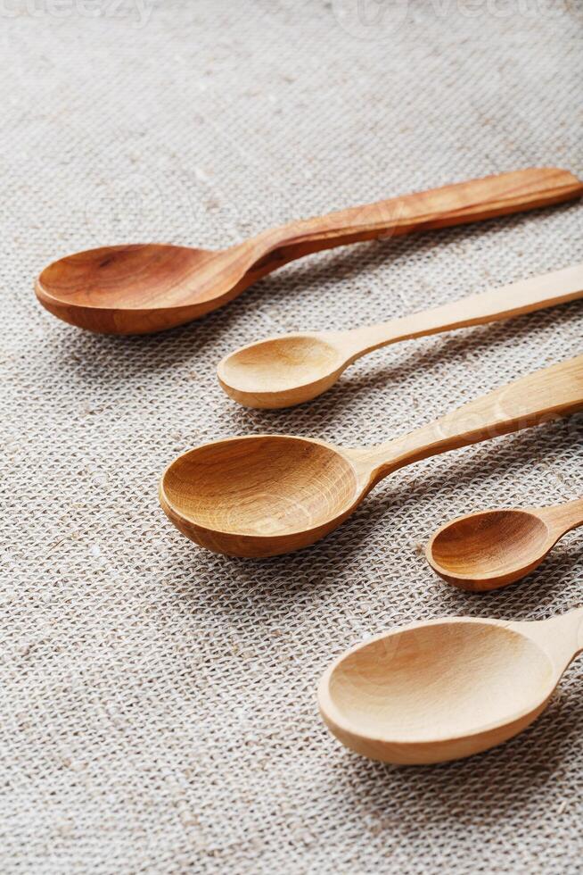 Wooden spoons made of natural wood on burlap fabric as a craft