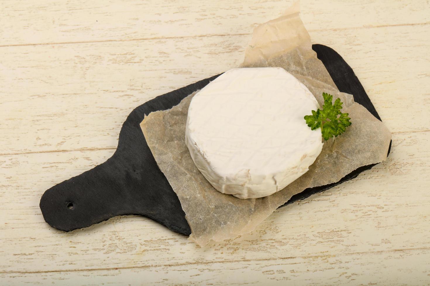 Camembert cheese on wooden board and wooden background photo