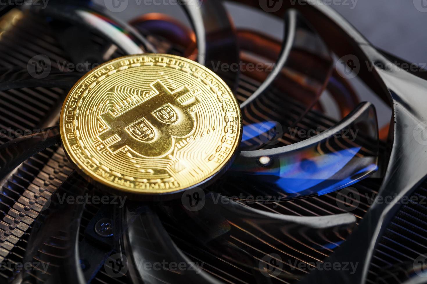 Video card with a gold coin Bitcoin on the cooler close-up. photo