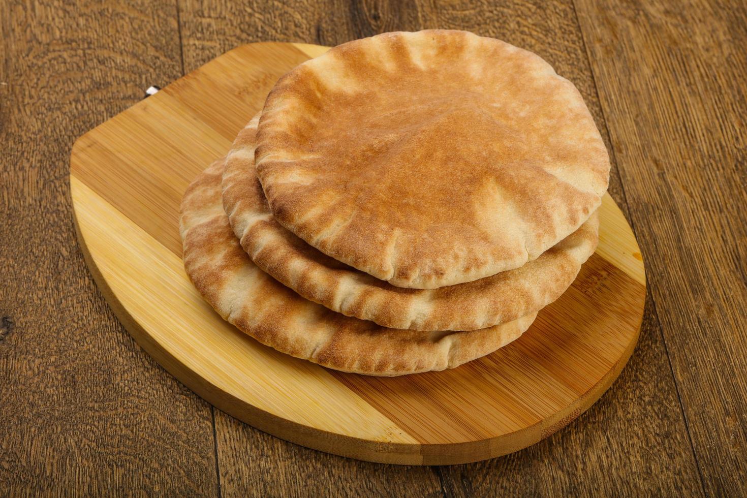 Pita bread on wooden board and wooden background photo