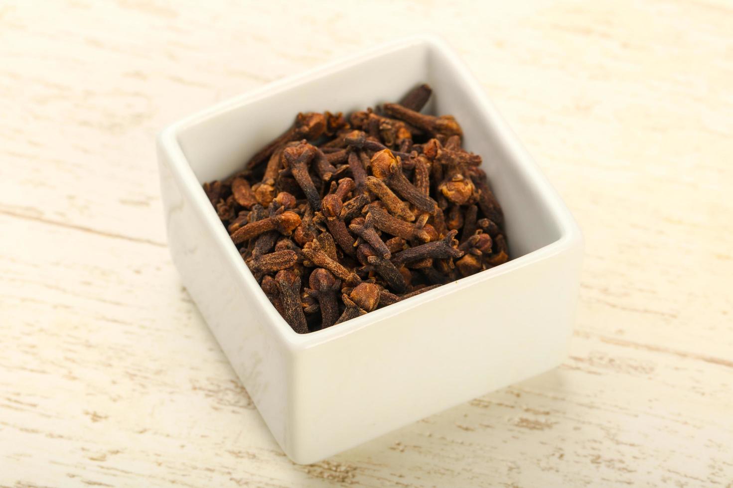 Clove in a bowl on wooden background photo