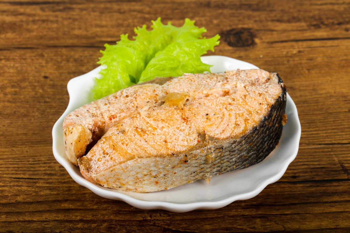Steamed salmon on the plate and wooden background photo