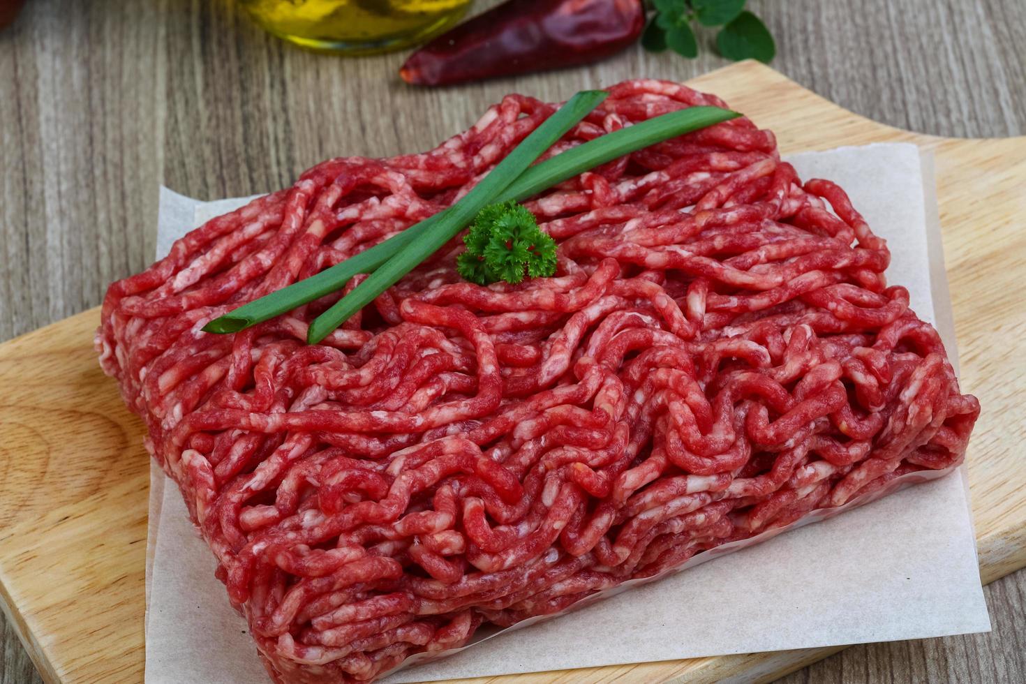 Minced beef on wooden board and wooden background photo