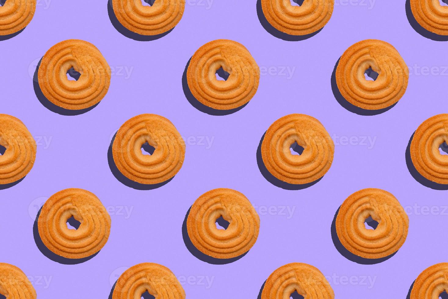 Seamless pattern with round cookies on a violet background photo