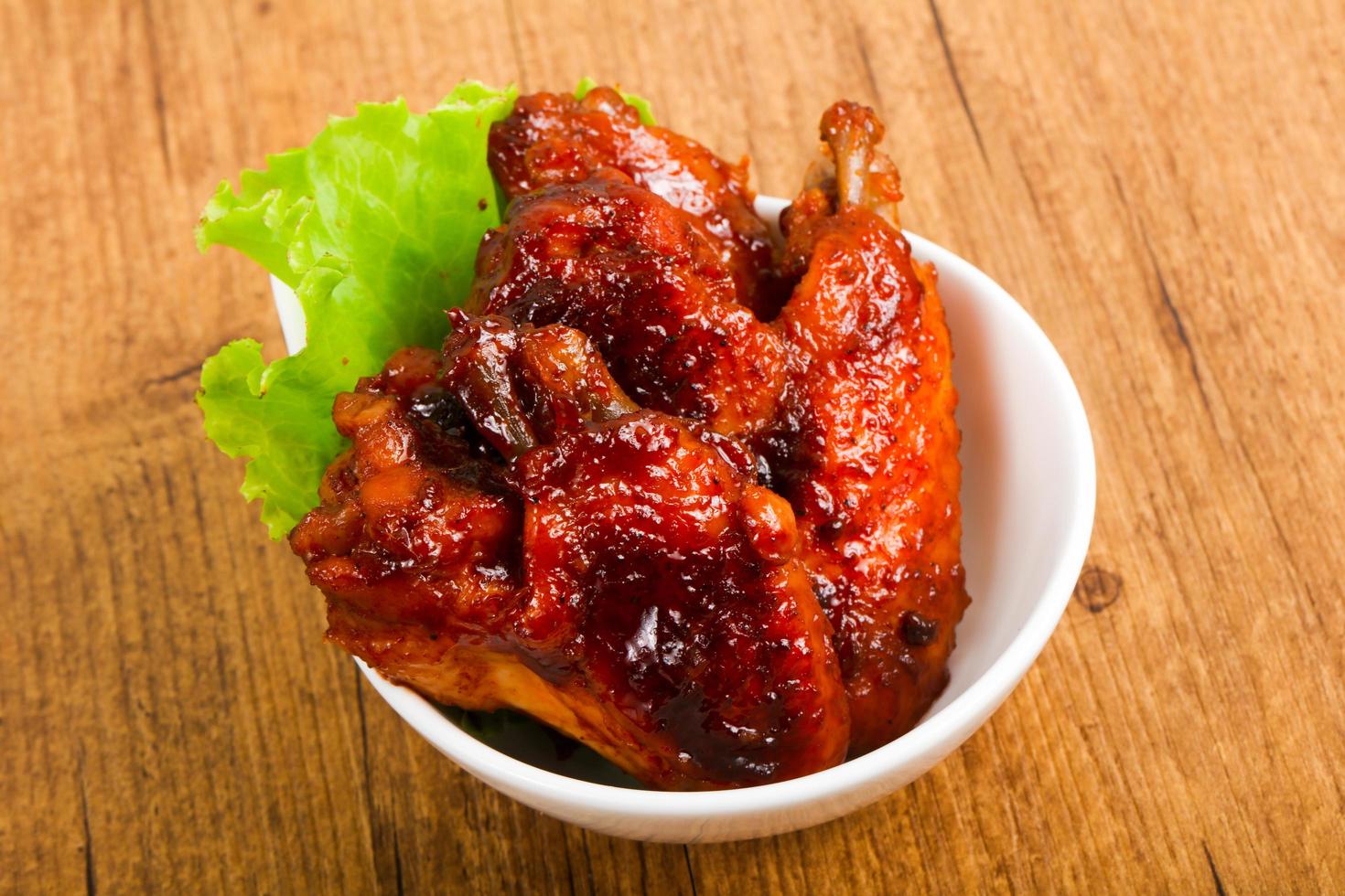 Chicken wings in a bowl on wooden background photo