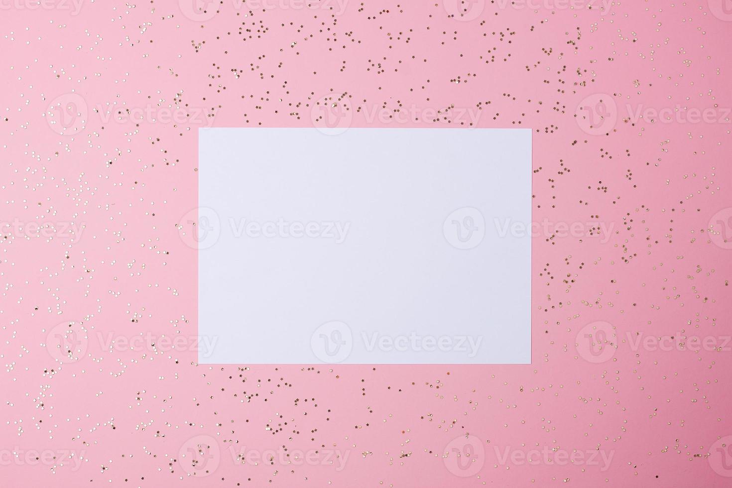 Christmas pink minimal background with mock up greetings card and confetti. Flat lay, copy space photo