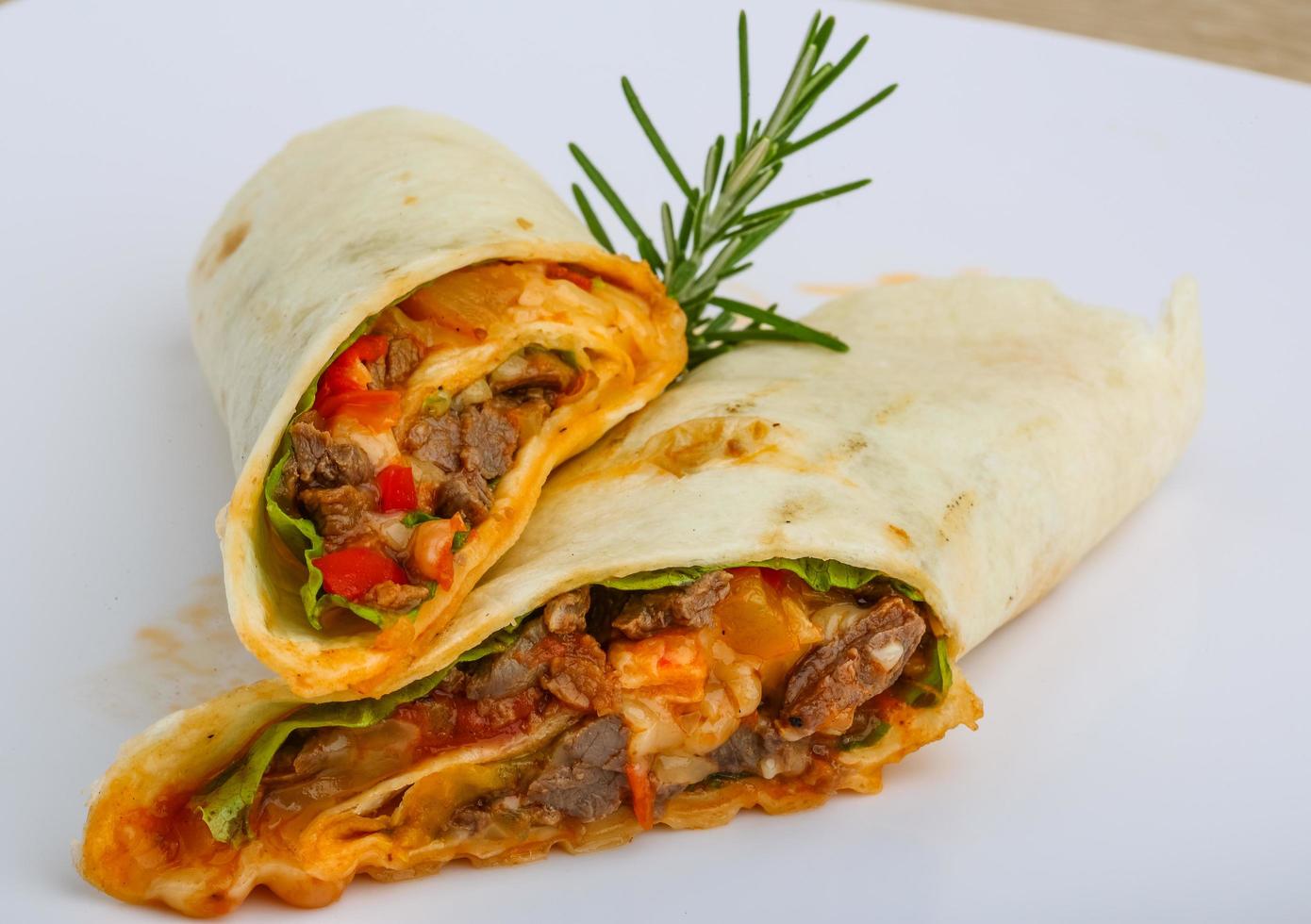 envuelva la tortilla en el plato y el fondo de madera foto