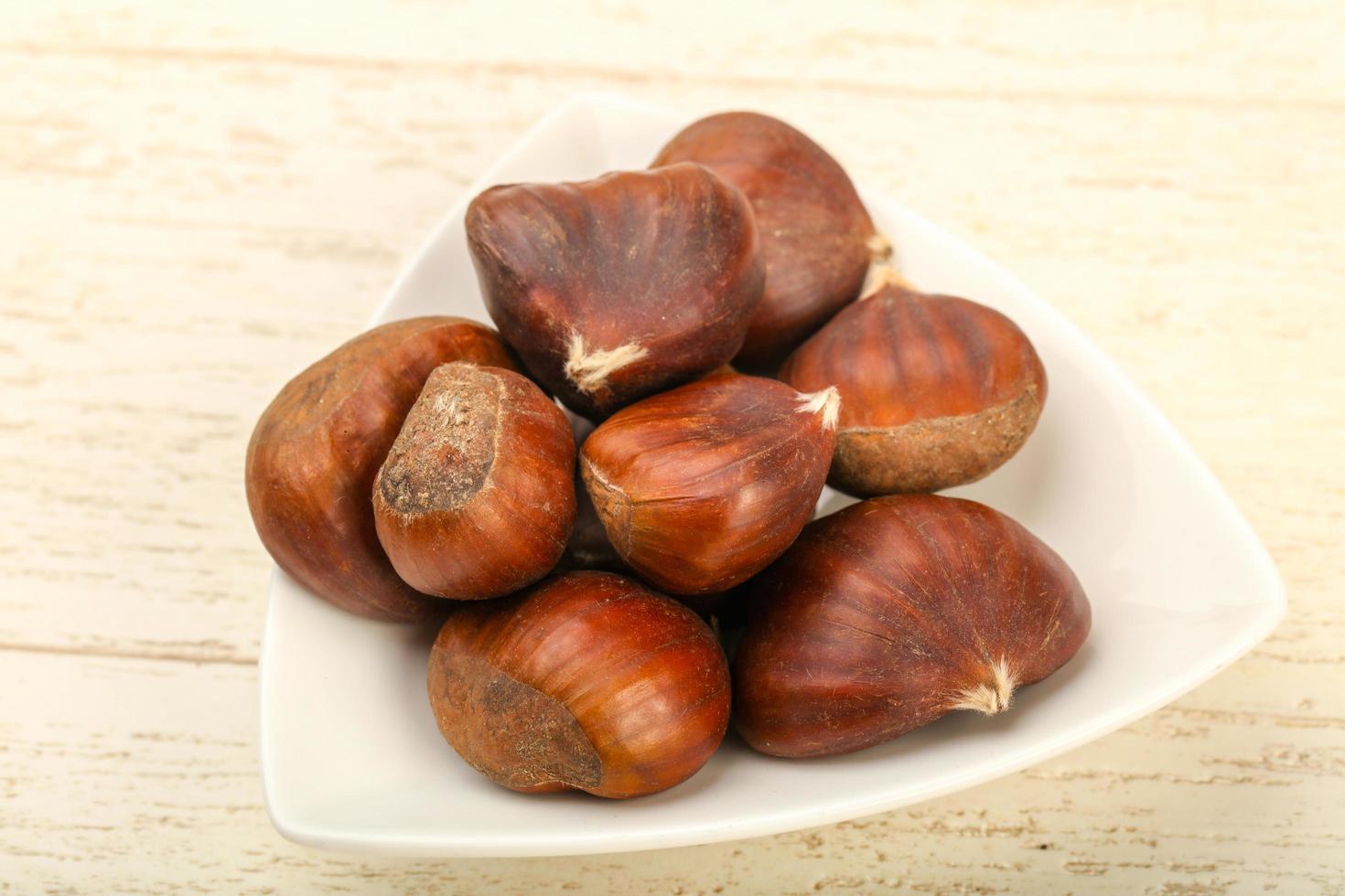 Chestnut in a bowl on wooden background photo