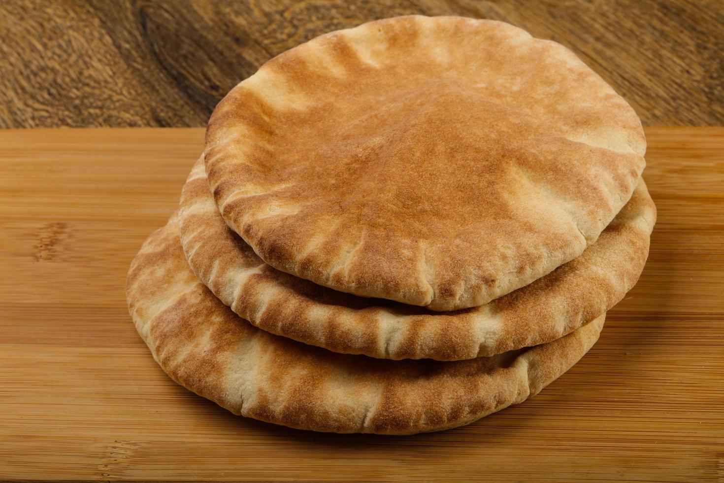 Pita bread on wooden board and wooden background photo