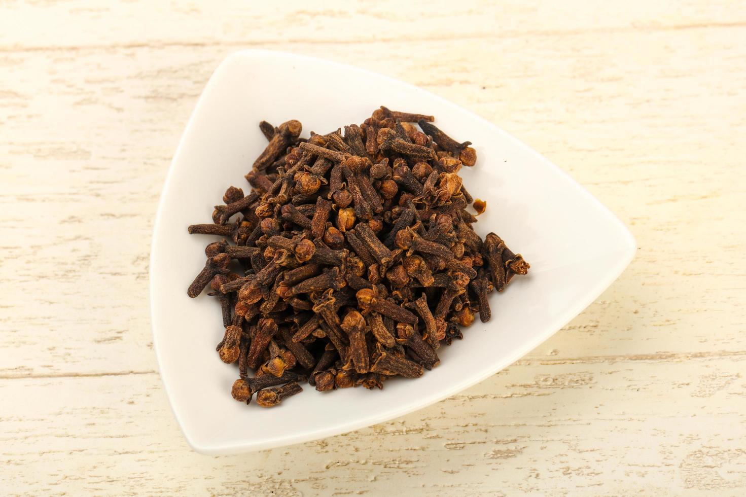 Clove in a bowl on wooden background photo