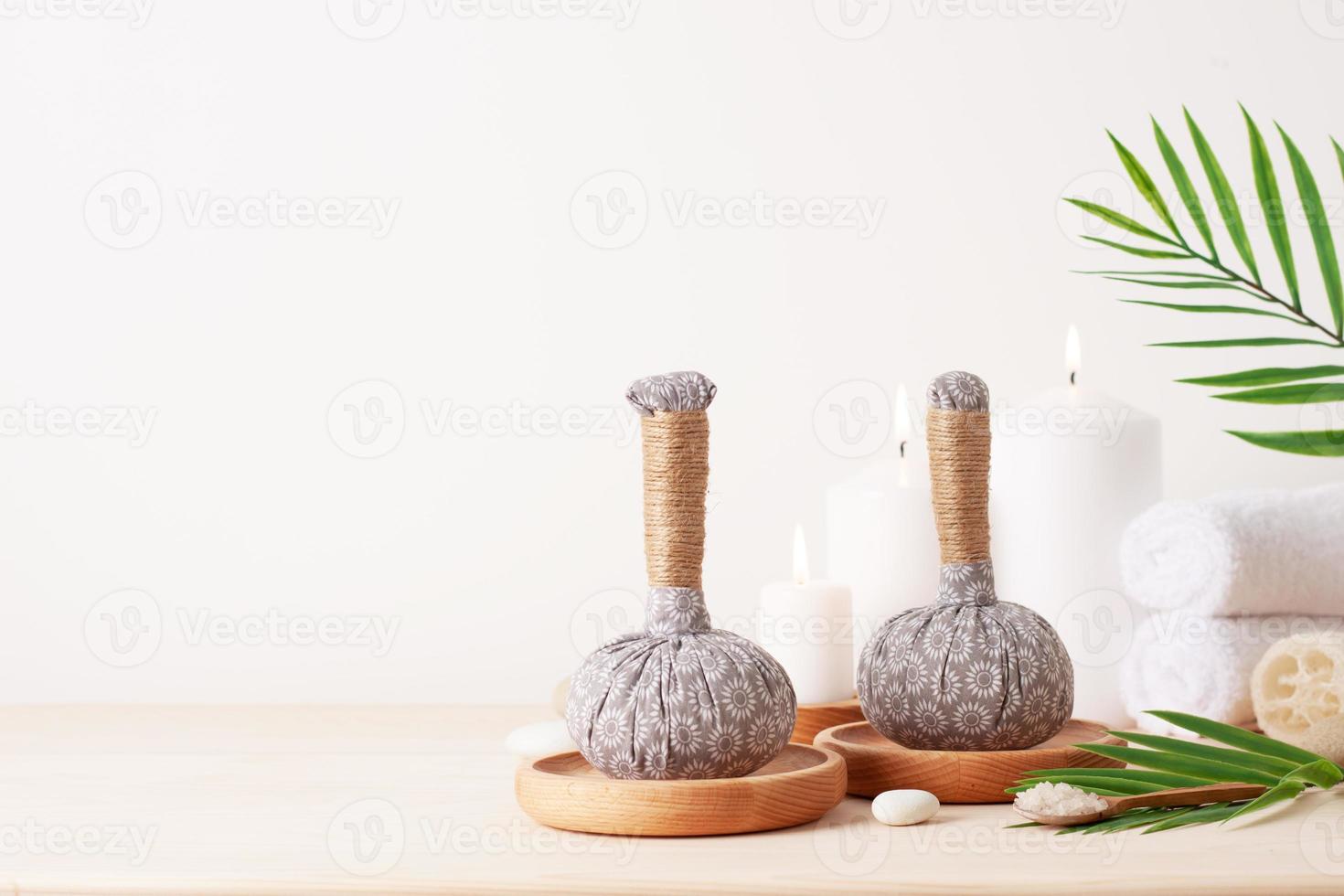 Spa treatment with herbal bags and candle on white background. Close up, copy space. photo