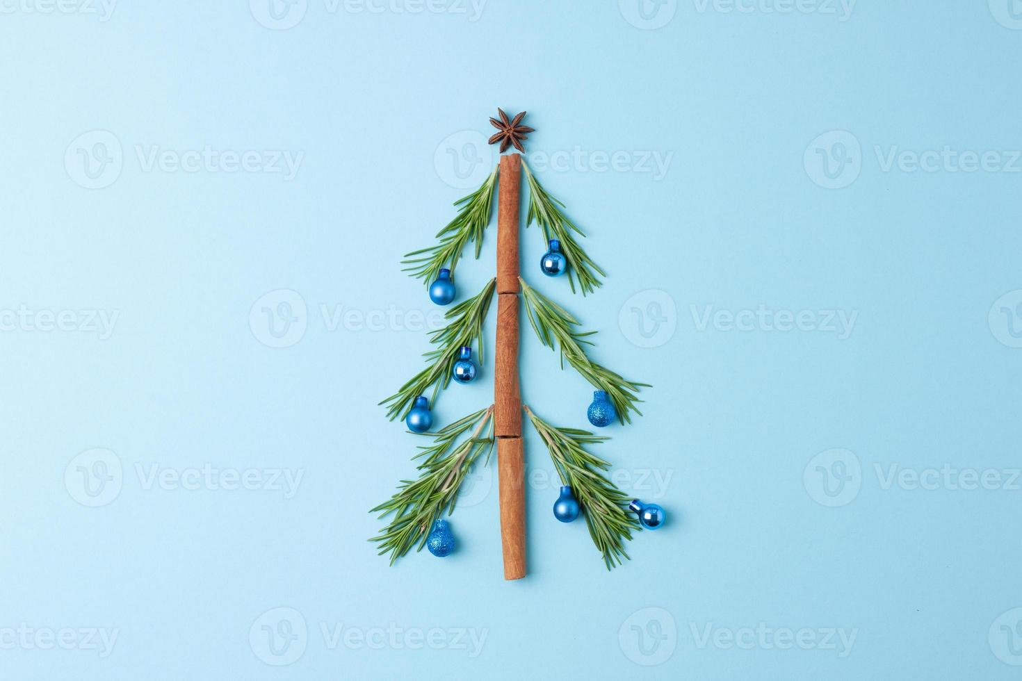 Christmas tree shape made with rosemary and balls blue background. Flat lay, copy space photo