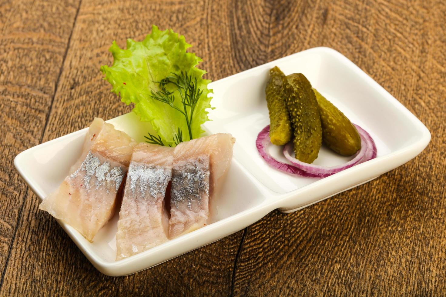 Herring fillet in a bowl on wooden background photo