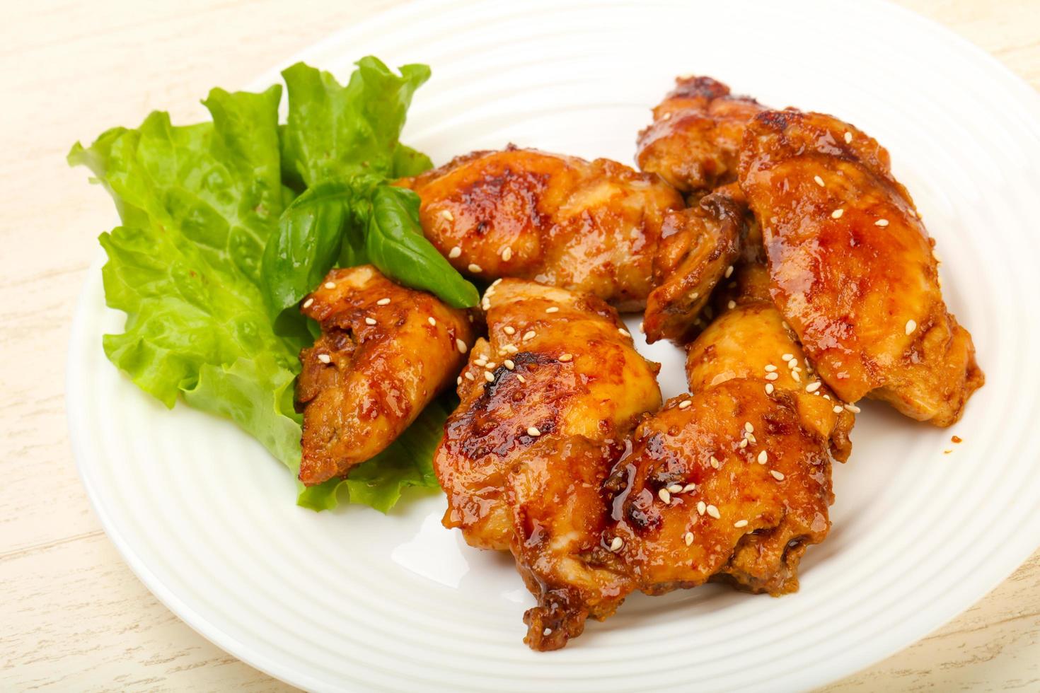 Teriyaki thighs on the plate and wooden background photo