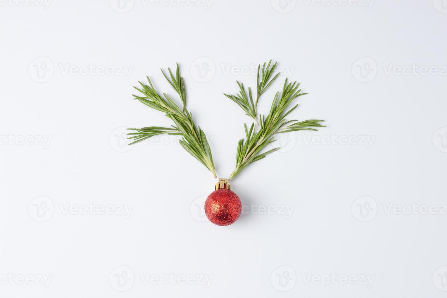 Christmas white minimal background with reindeer antlers made with red ball and rosemary. Flat lay, copy space photo