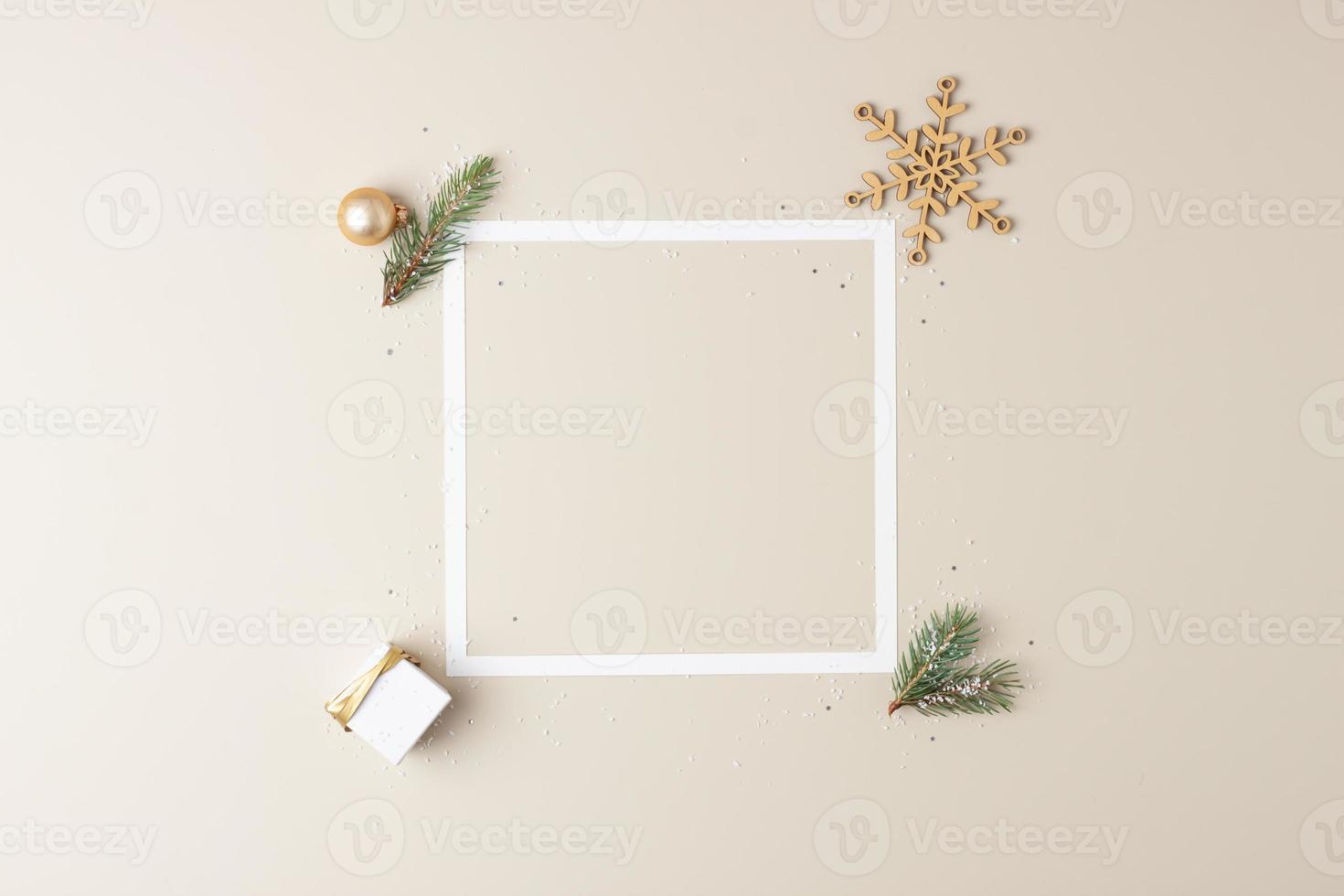 Christmas minimal composition with white frame and packaging gift on pastel beige background. Flat lay, copy space photo