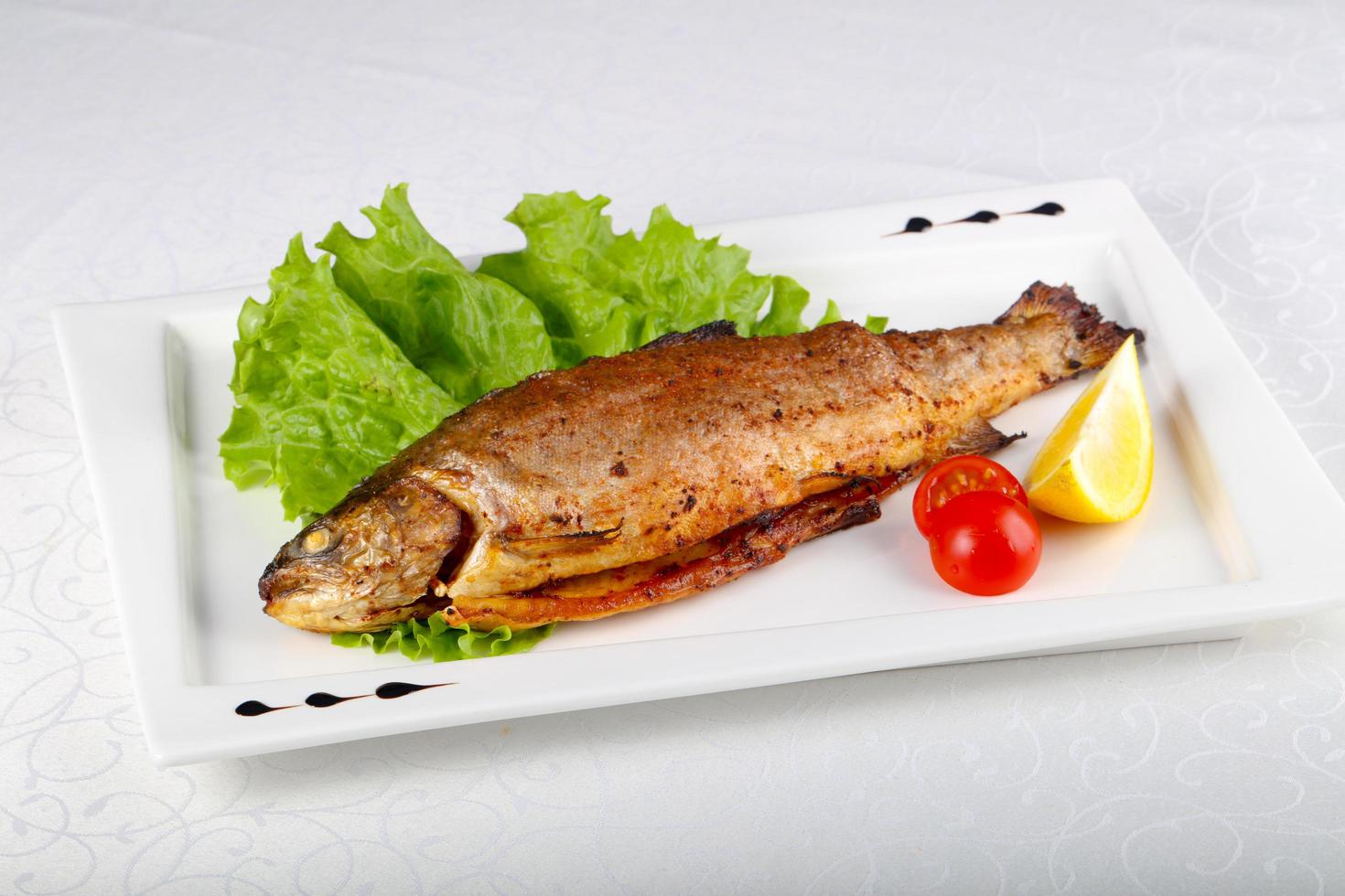 Grilled trout on the plate and white background photo