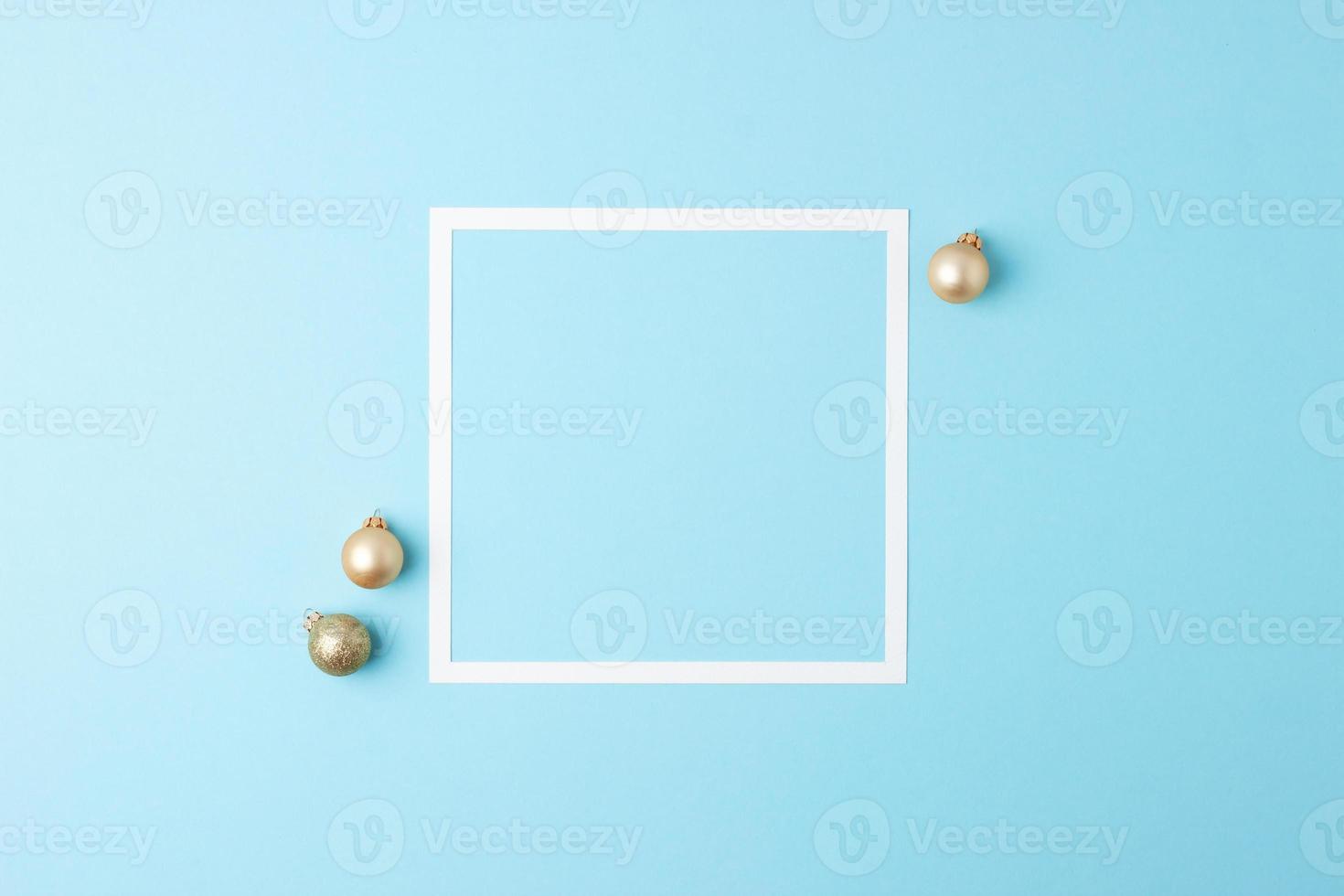 Christmas blue minimal background with white frame and beige ball. Flat lay, copy space photo