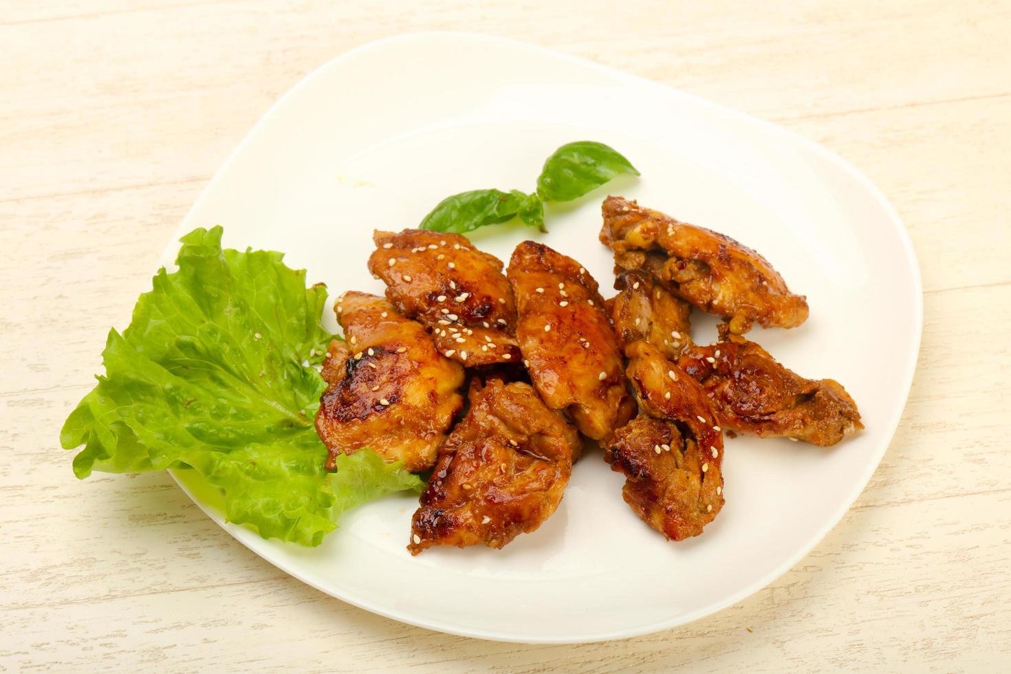 Teriyaki thighs on the plate and wooden background photo