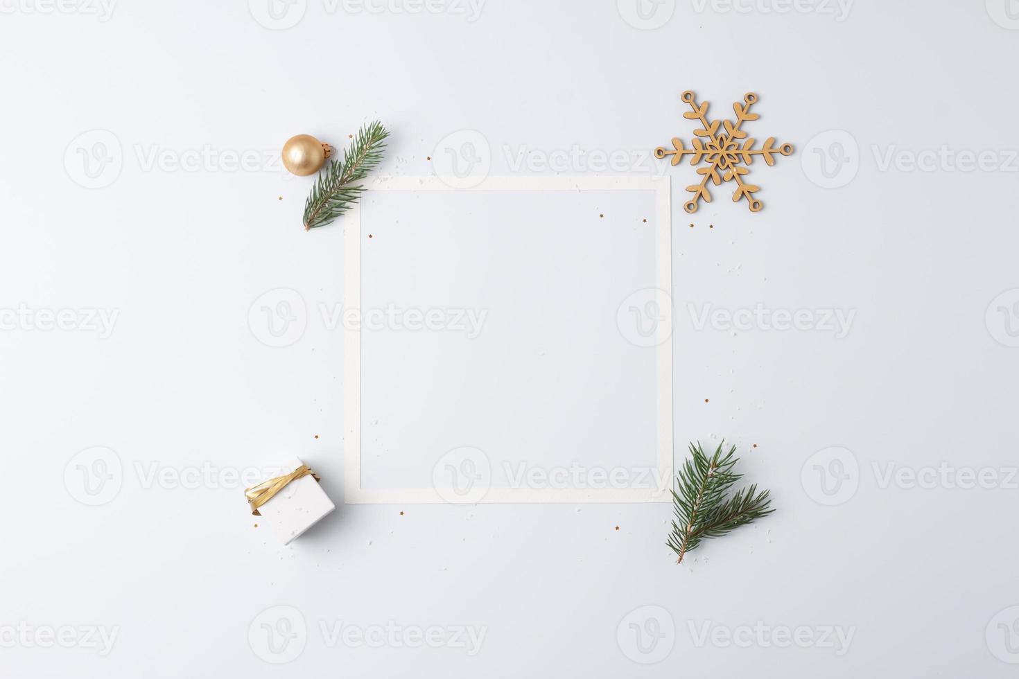 Christmas decorations with white frame and gift on white background. Flat lay, copy space photo