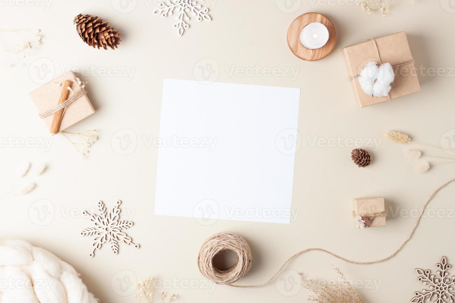 Christmas background with mock up greetings card and Christmas decorations on pastel beige. Flat lay, copy space photo