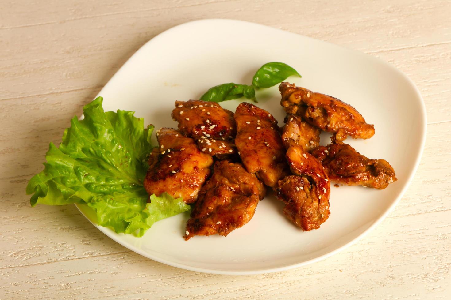 Teriyaki thighs on the plate and wooden background photo