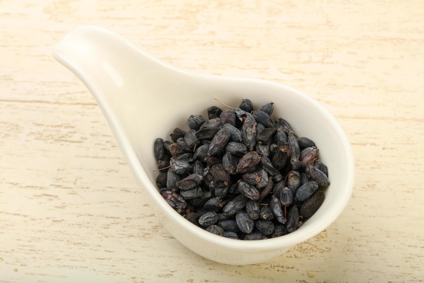 Dry barberry in a bowl on wooden background photo