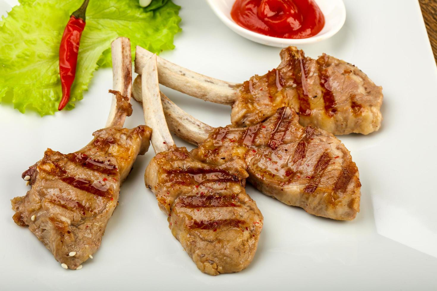 Grilled lamb on the plate and wooden background photo