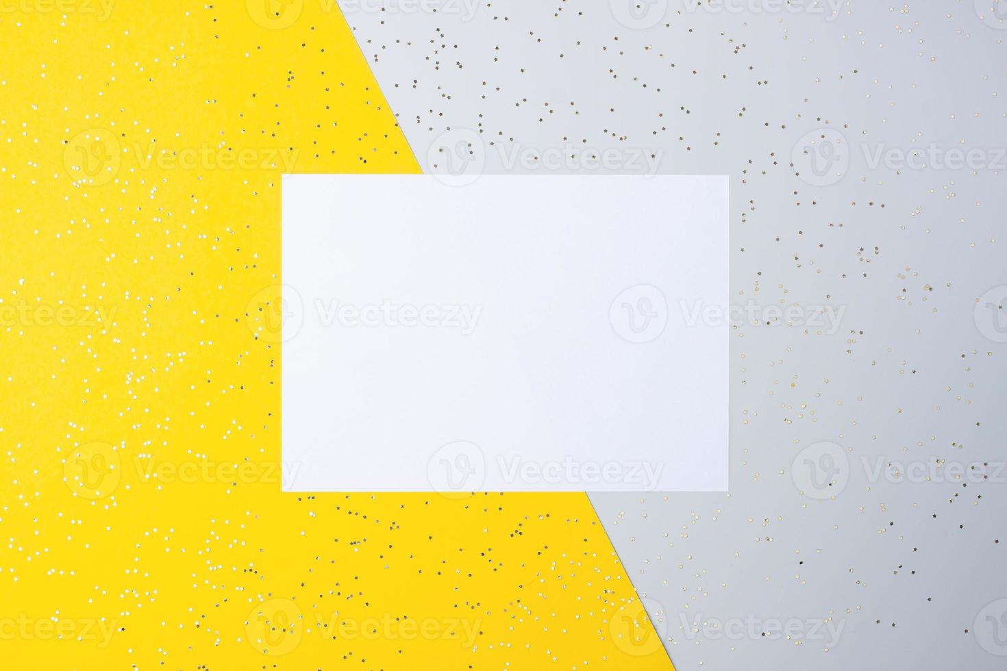 Christmas yellow and grey minimal background with mock up greetings card and confetti. Flat lay, copy space photo