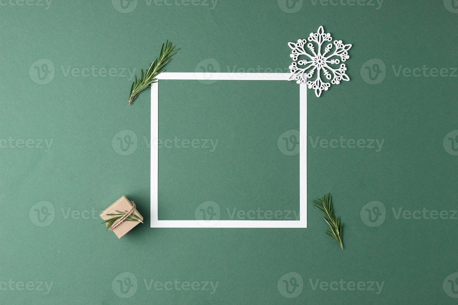 Christmas green minimal background with white frame and gift. Zero waste Christmas holiday concept. Flat lay, copy space photo
