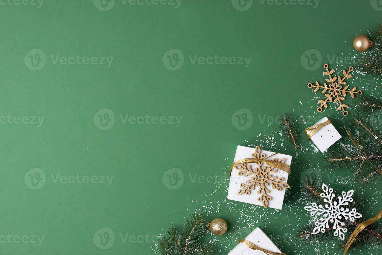 Christmas decorations with packaging gifts and Christmas tree on green background. Flat lay, copy space photo