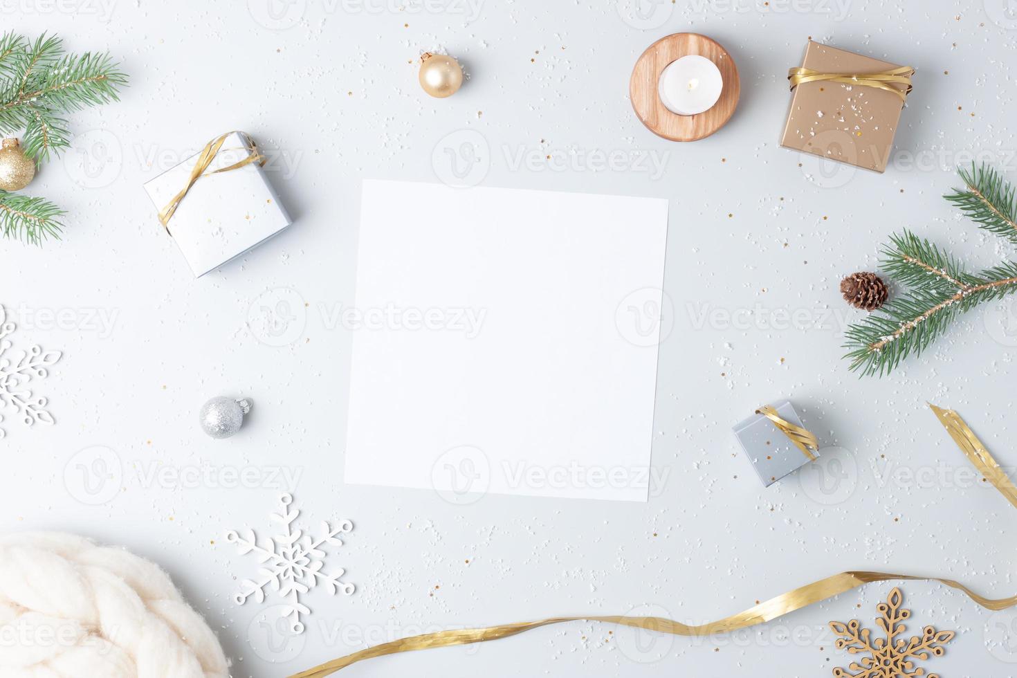 fondo de navidad con tarjeta de felicitación simulada y adornos navideños en gris. endecha plana, espacio de copia foto