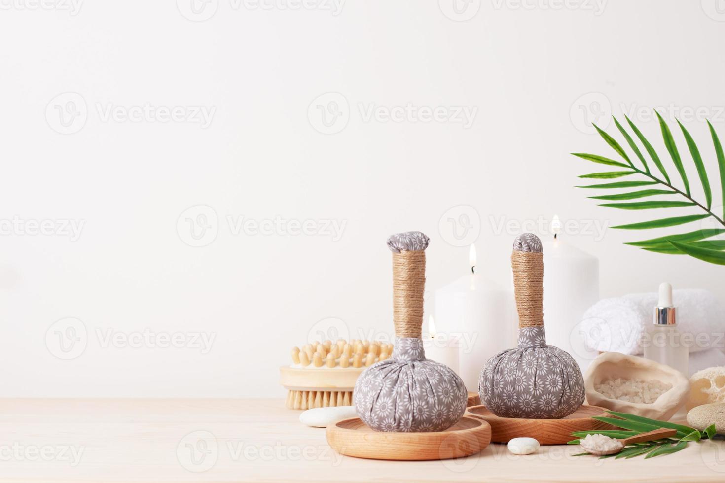 Spa treatment with herbal bags and candle on white background. Close up, copy space. photo