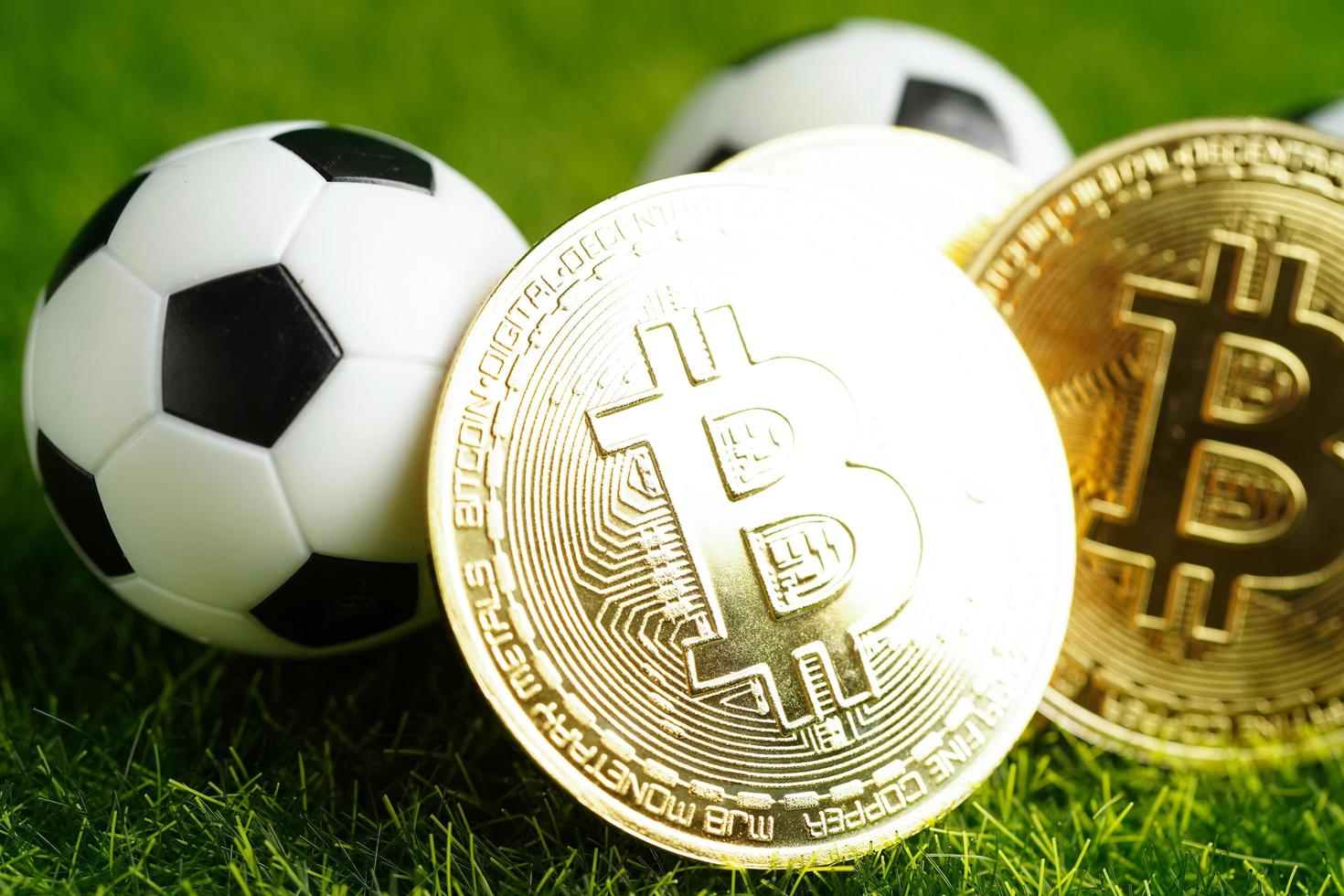 Gold bitcoin with soccer ball or football, cryptocurrency used in online sports betting. photo