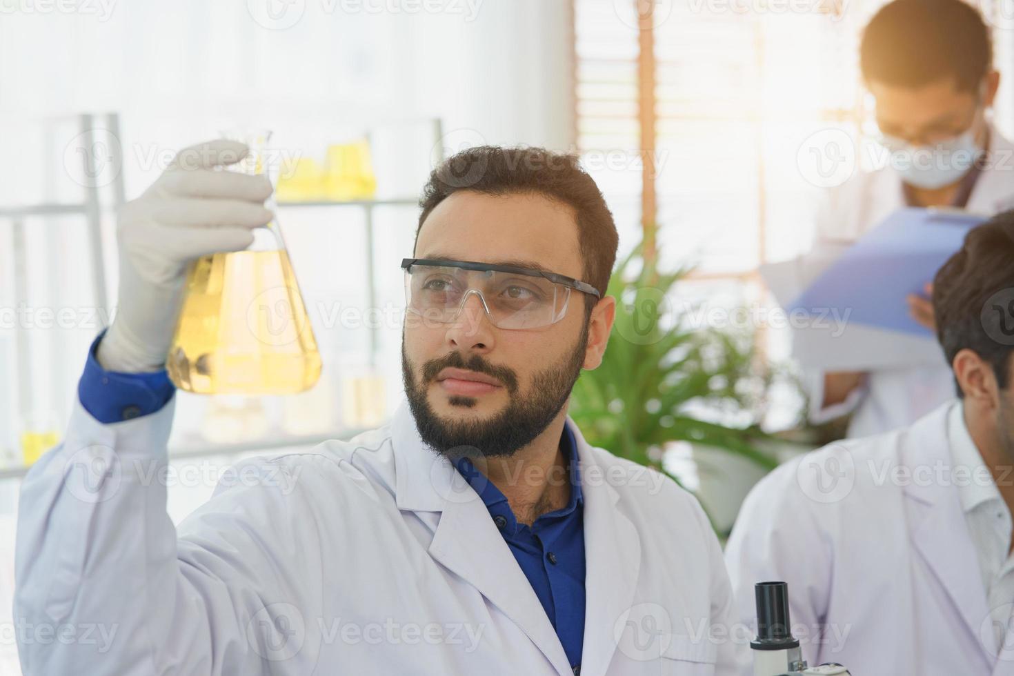 Experto científico del hombre del Medio Oriente en investigación de laboratorio, descubrimiento de biología, tubo de ensayo, análisis de extracto, biotecnología, examen, estudiante de doctor, aprendizaje, farmacia médica, laboratorio químico, científico. foto