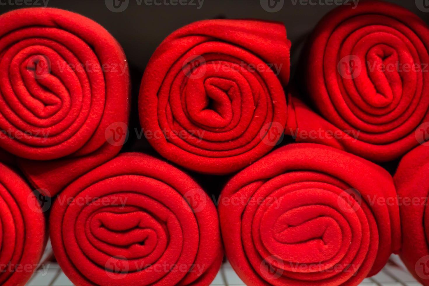 Rolls of many red plaids on the shelf photo