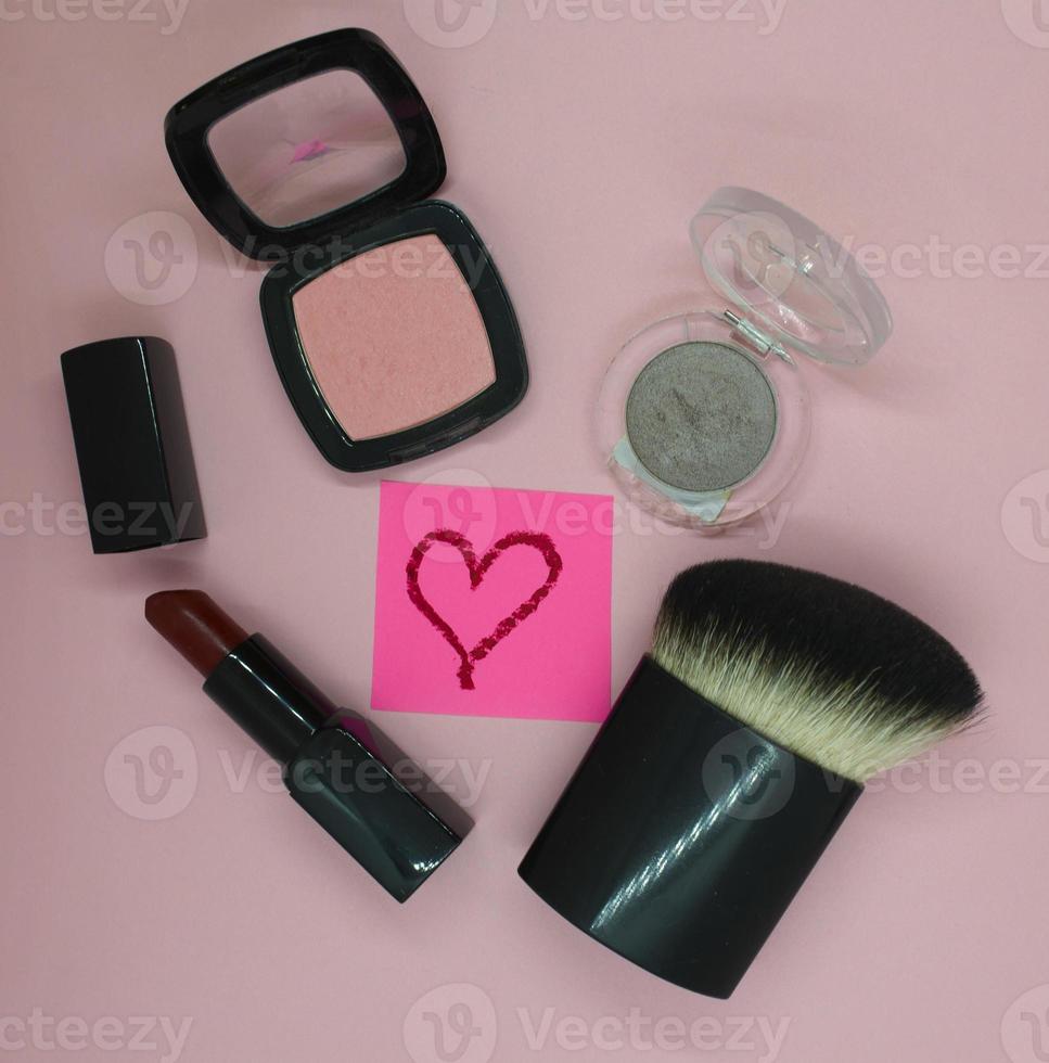 Cosmetic brush, blush, red lipstick, eye shadow photo